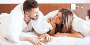 Married couple cuddling in bed, illustrating intimacy and emotional connection in marriage
